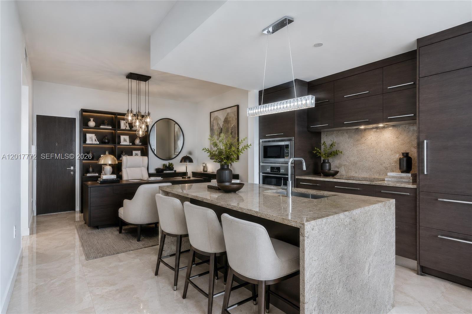 A modern kitchen with a stone island and bar seating adjacent to a home office — 900 Biscayne Blvd # 4205, Miami FL 33132, MIAMI, FL