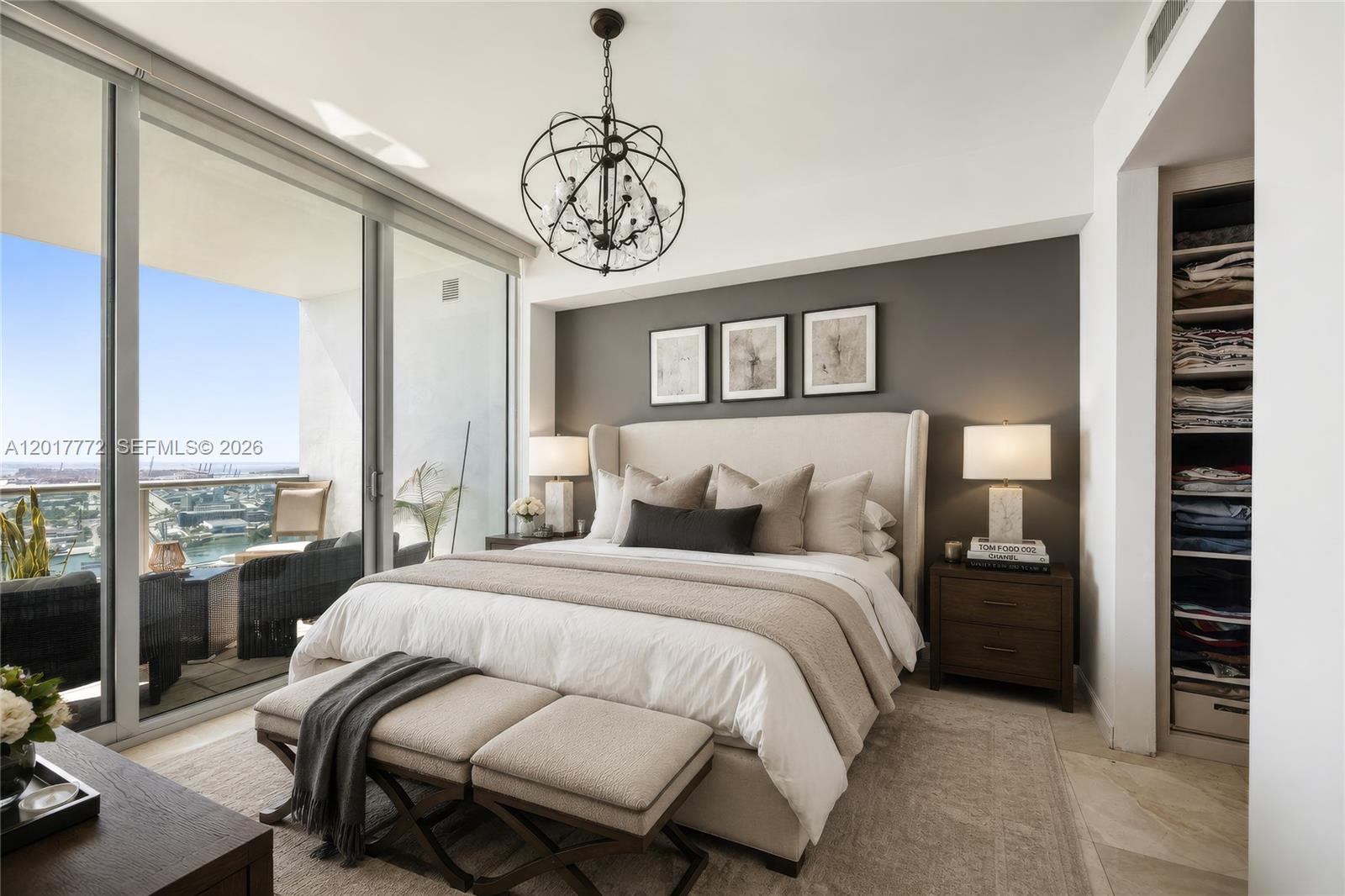 A bedroom features a king bed, a dark accent wall, and a balcony with water views — 900 Biscayne Blvd # 4205, Miami FL 33132, MIAMI, FL