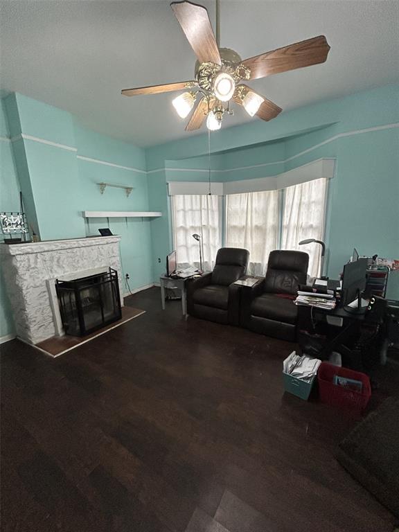A living room features a white stone fireplace, light blue walls, and dark wood flooring — 103 E WARD AVENUE, EUSTIS, FL