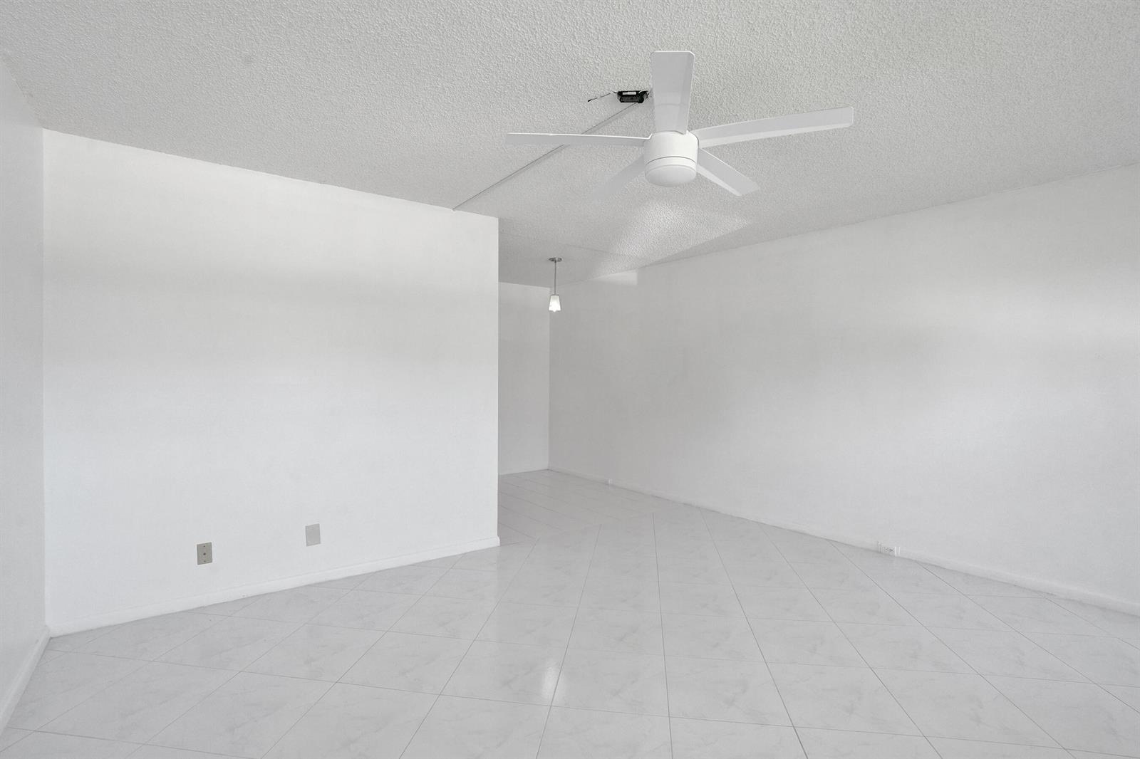 An empty room with white walls, white tile flooring, and a ceiling fan — 392 Durham Circle # M, Deerfield Beach FL 33442, DEERFIELD BEACH, FL