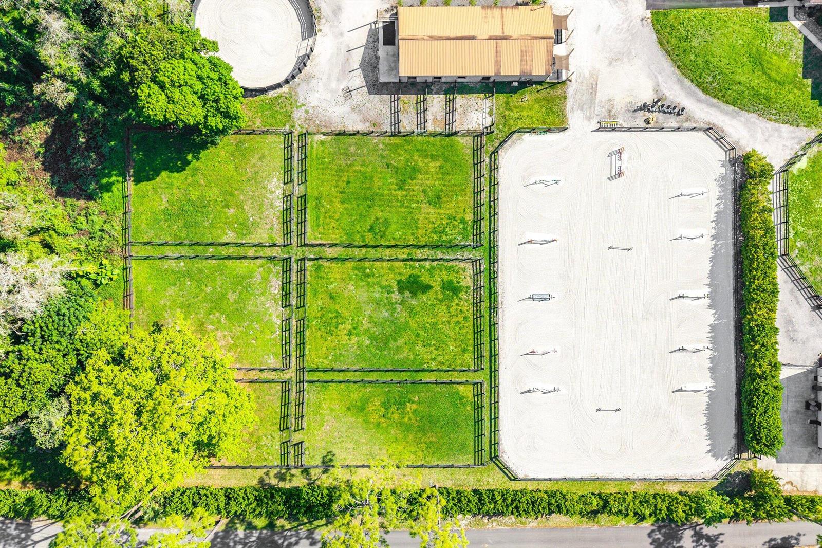 An aerial view shows a horse riding arena, fenced pastures, and a barn on property — 6149 Park Lane E, Lake Worth FL 33449, LAKE WORTH, FL