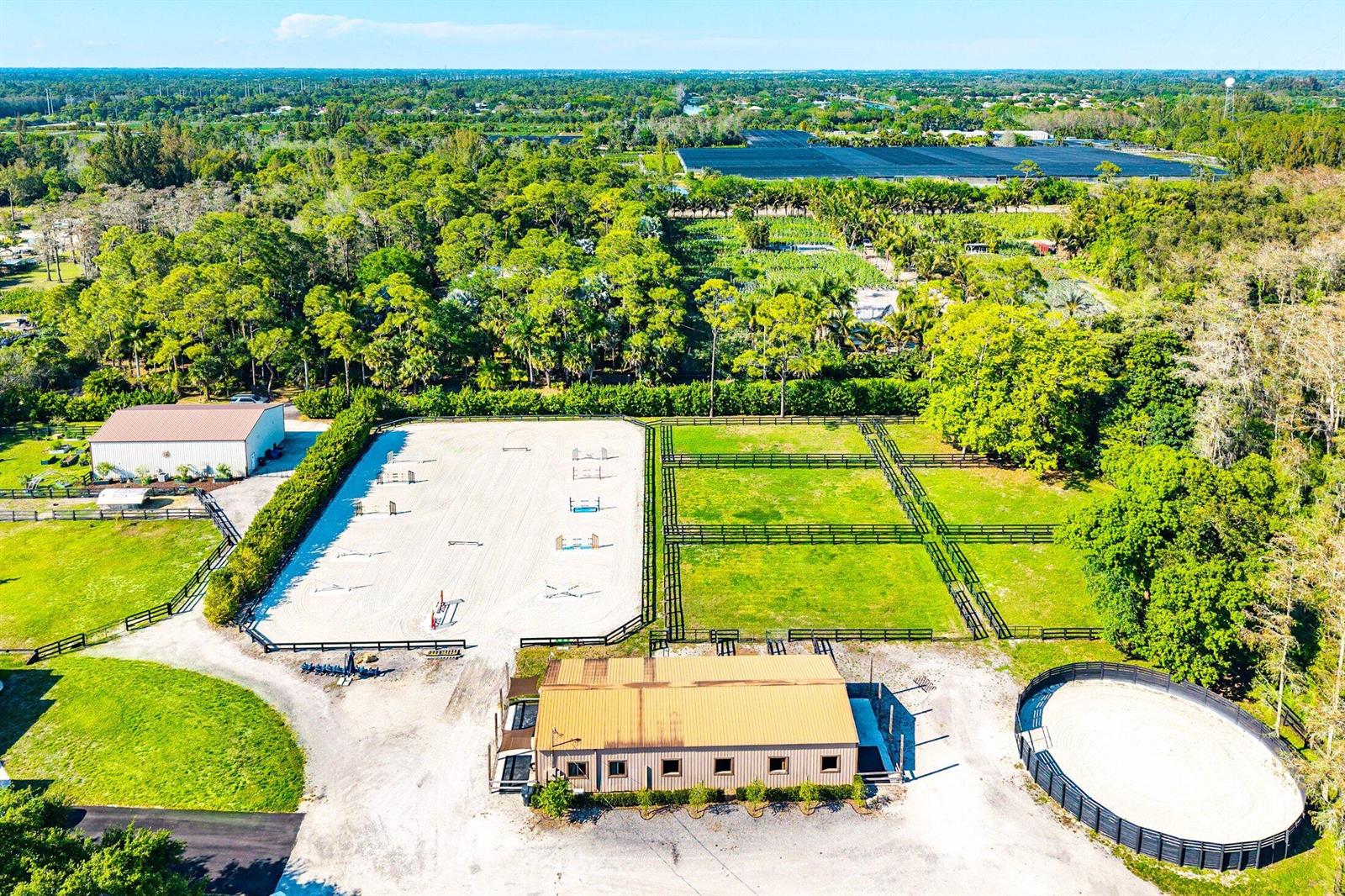 An aerial view shows a horse farm with a riding arena, stables, and fenced pastures — 6149 Park Lane E, Lake Worth FL 33449, LAKE WORTH, FL
