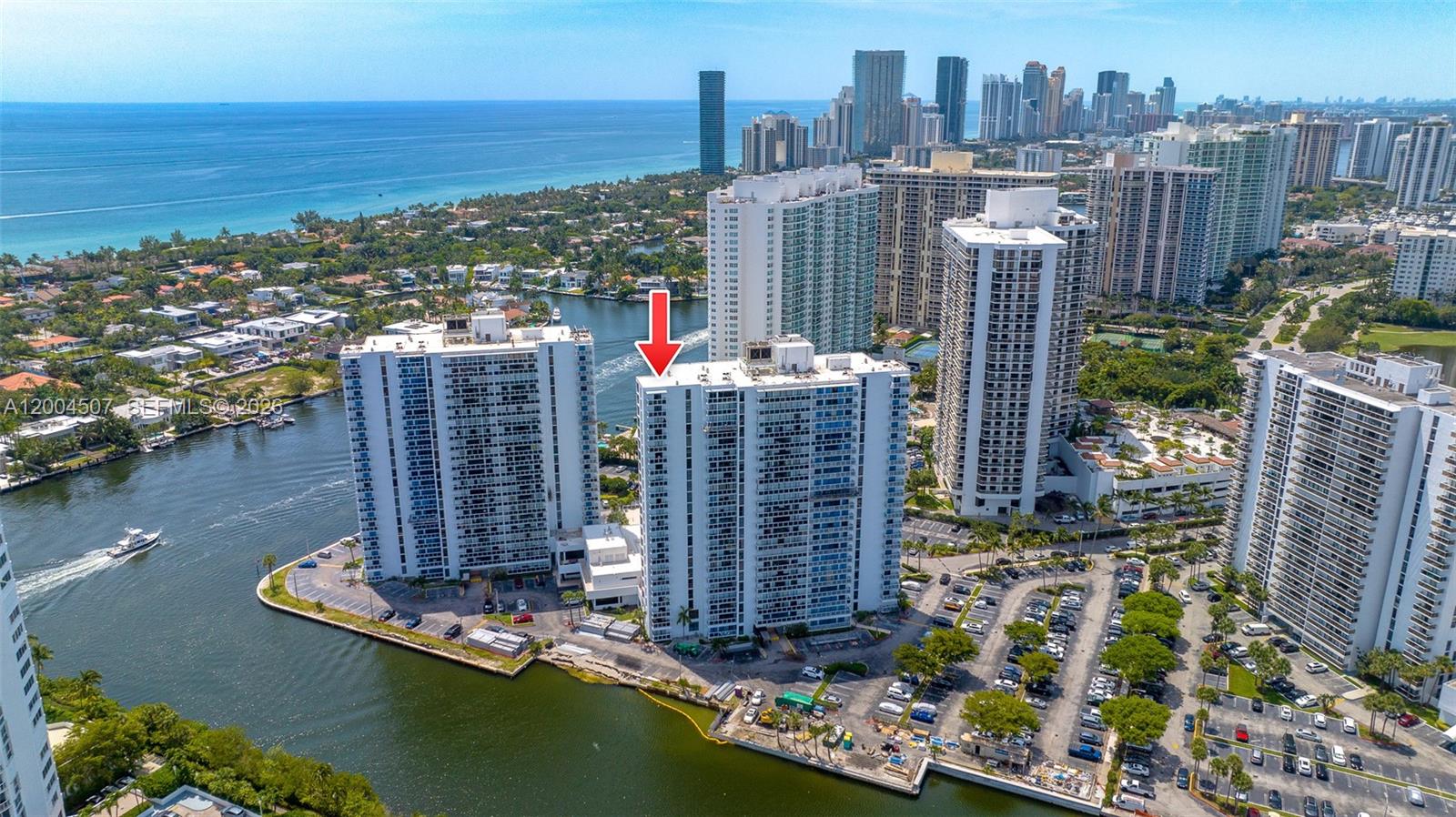 An aerial view shows high-rise residential buildings situated along a waterway near the ocean — 20505 E Country Club Dr # 38, Aventura FL 33180, AVENTURA, FL