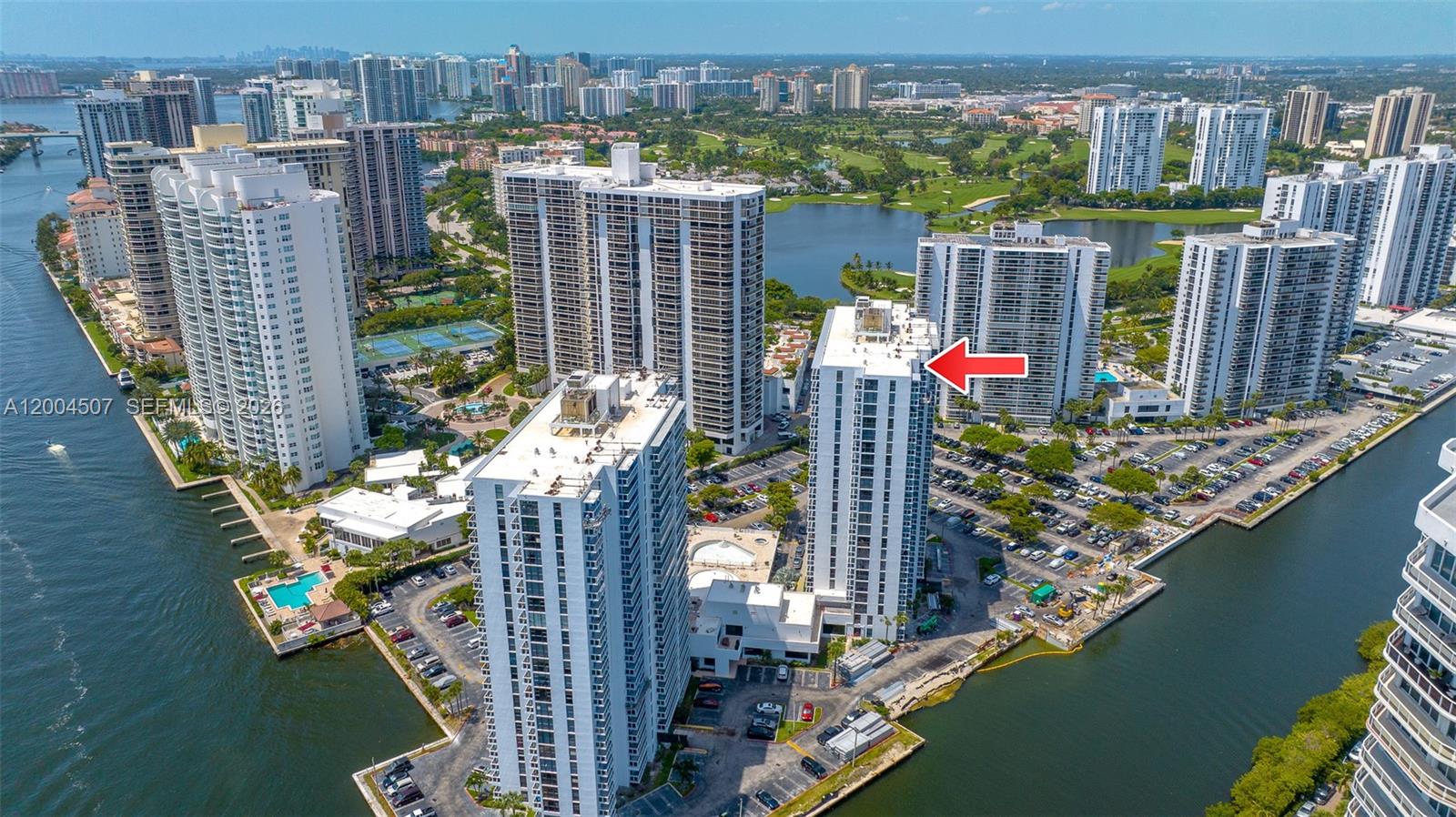 An aerial view shows several high-rise residential buildings surrounded by water and parking lots — 20505 E Country Club Dr # 38, Aventura FL 33180, AVENTURA, FL