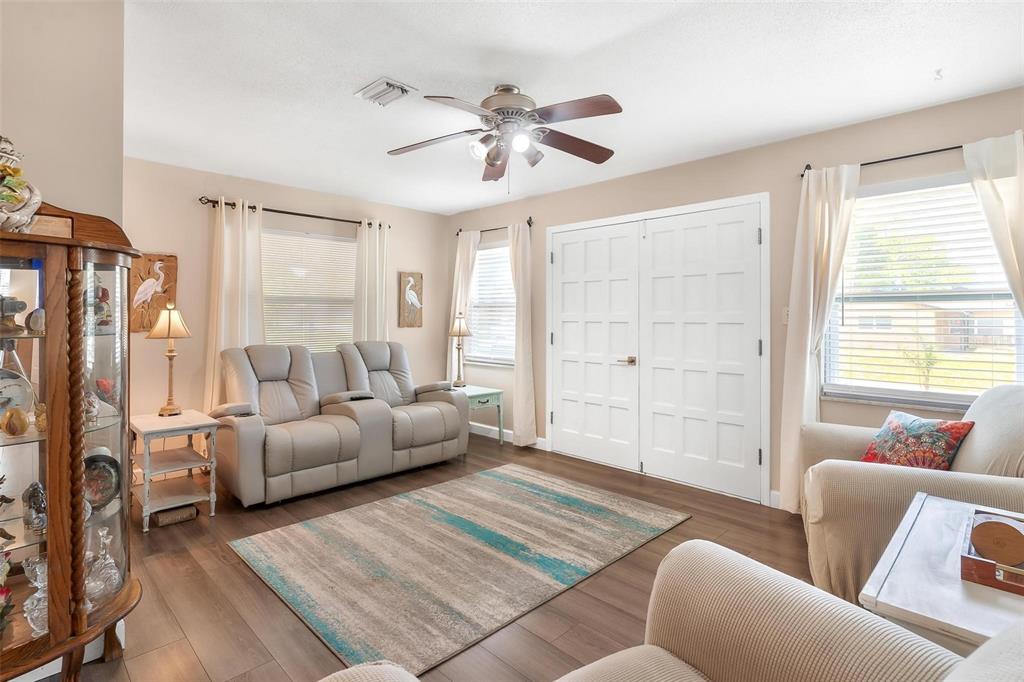 A living room features light-colored furniture, a patterned area rug, and white double doors — 709 CINDY AVENUE, FRUITLAND PARK, FL