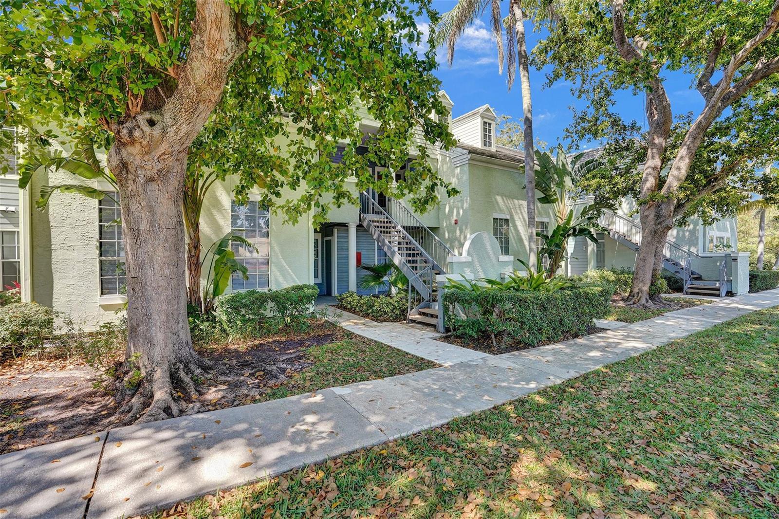 A two-story apartment building with light green stucco walls and an exterior metal staircase — 1050 Crystal Way, Delray Beach FL 33444, DELRAY BEACH, FL