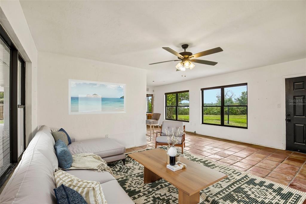 A living room features a sectional sofa, a wooden coffee table, and tile flooring — 807 LUCILLE AVENUE, NOKOMIS, FL