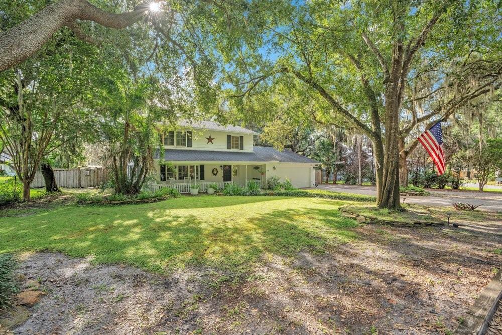 A two-story house with a white exterior, a front porch, and a large front yard — 725 OAKDALE STREET, WINDERMERE, FL