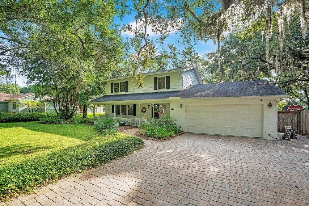 A two-story house with a white exterior, a paved driveway, and a large front lawn — 725 OAKDALE STREET, WINDERMERE, FL