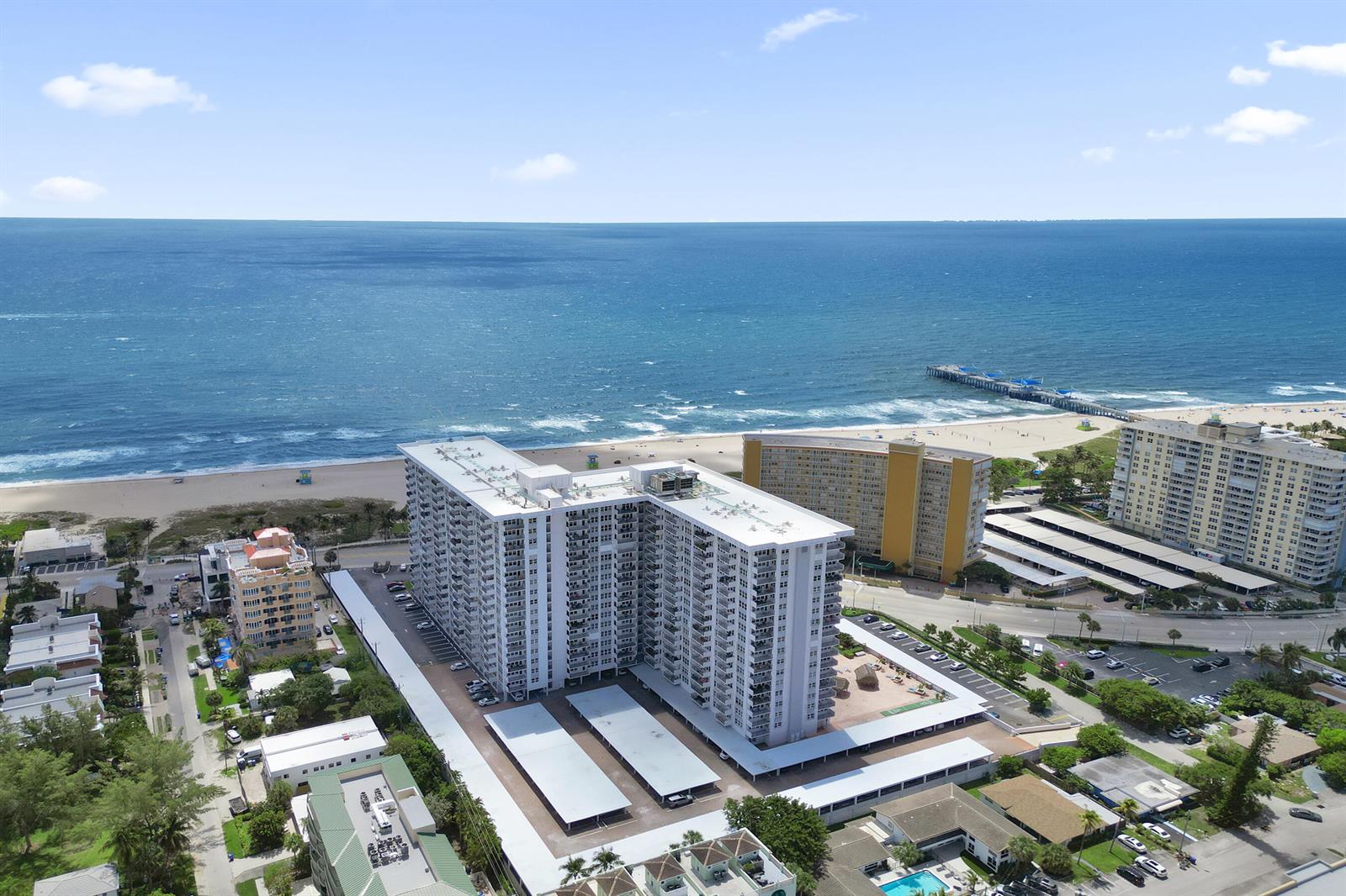 An aerial view shows high-rise apartment buildings near a sandy beach and the ocean — 405 N Ocean Boulevard # 1929, Pompano Beach FL 33062, POMPANO BEACH, FL