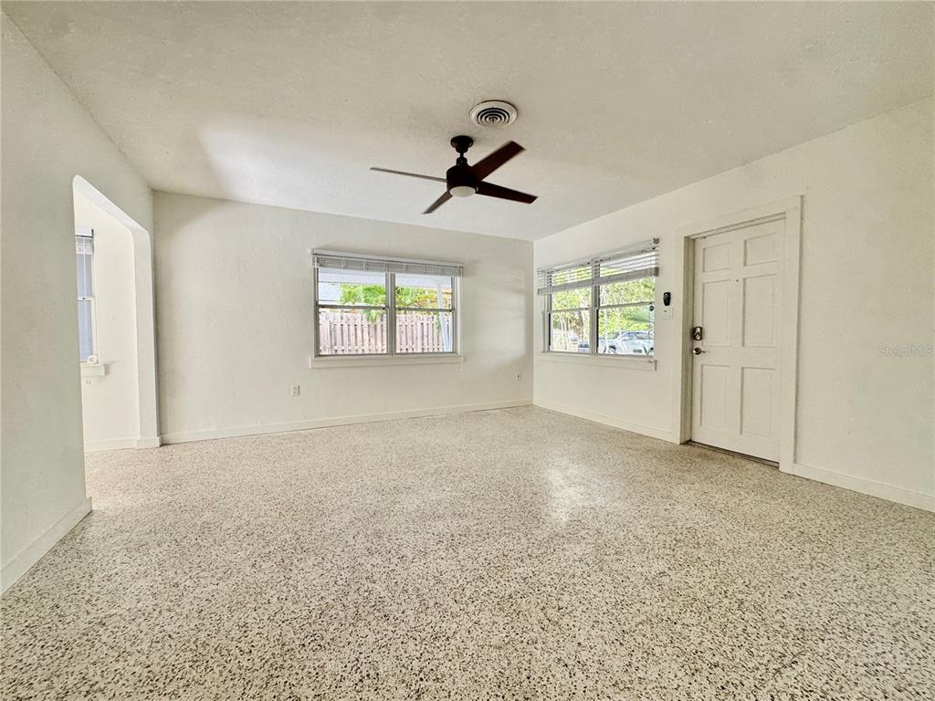 An empty room with white walls, a ceiling fan, and speckled flooring — 4722 STEVENS DRIVE, SARASOTA, FL