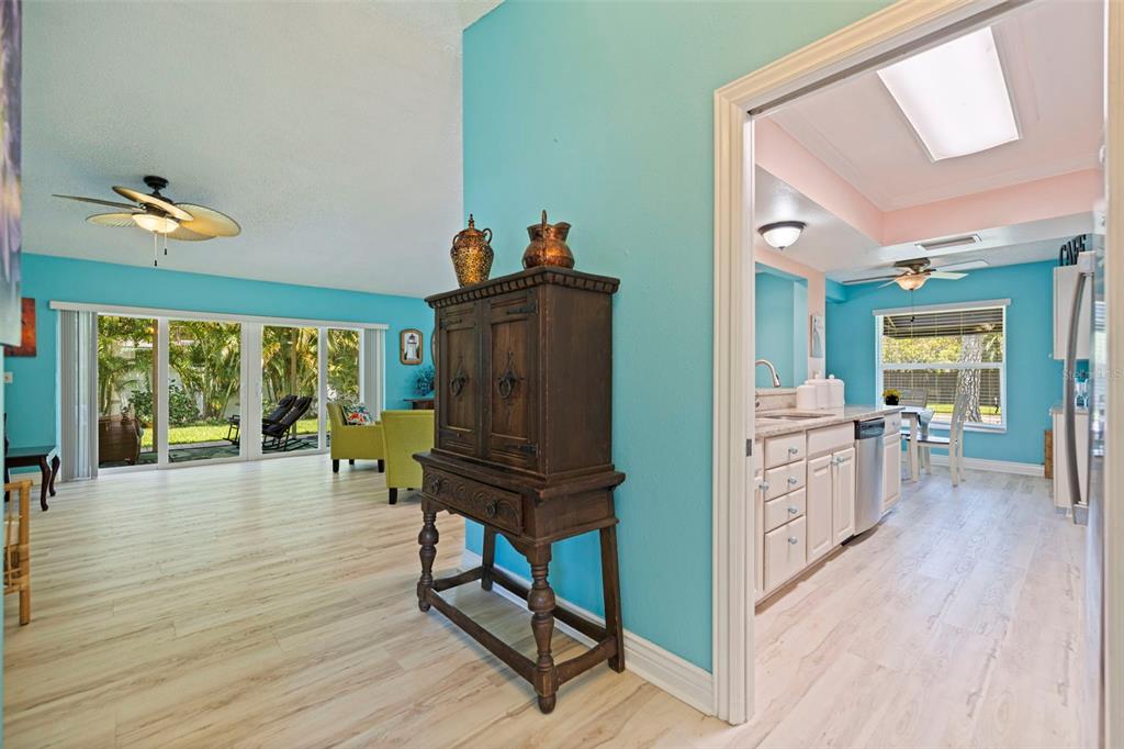 A view from a hallway looking into a living room and a kitchen with blue walls — 201 58TH AVENUE S, ST PETERSBURG, FL
