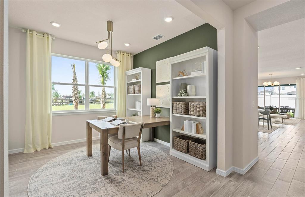 A home office features a wooden desk, white bookshelves, and a green accent wall — 2615 HAMMOCK HARBOR AVENUE, ST CLOUD, FL