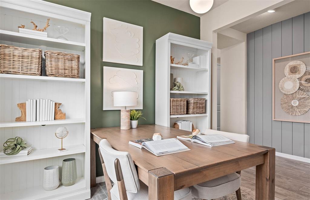A home office features a wooden desk, white bookshelves, and a green accent wall — 2615 HAMMOCK HARBOR AVENUE, ST CLOUD, FL