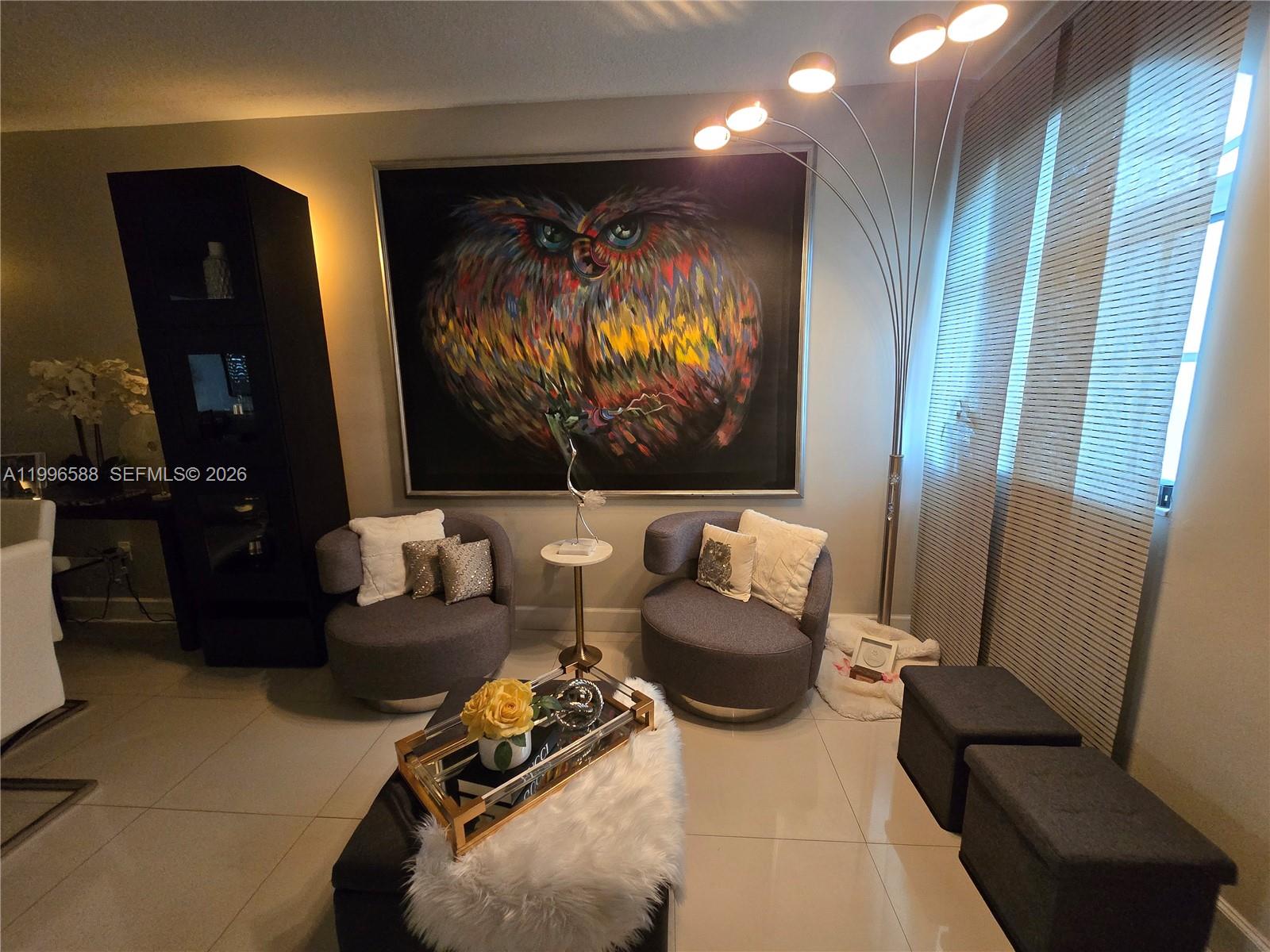 A living area features two gray armchairs, a large owl painting, and a floor lamp — 8441 SW 124th Ave # 106, Miami FL 33183, MIAMI, FL
