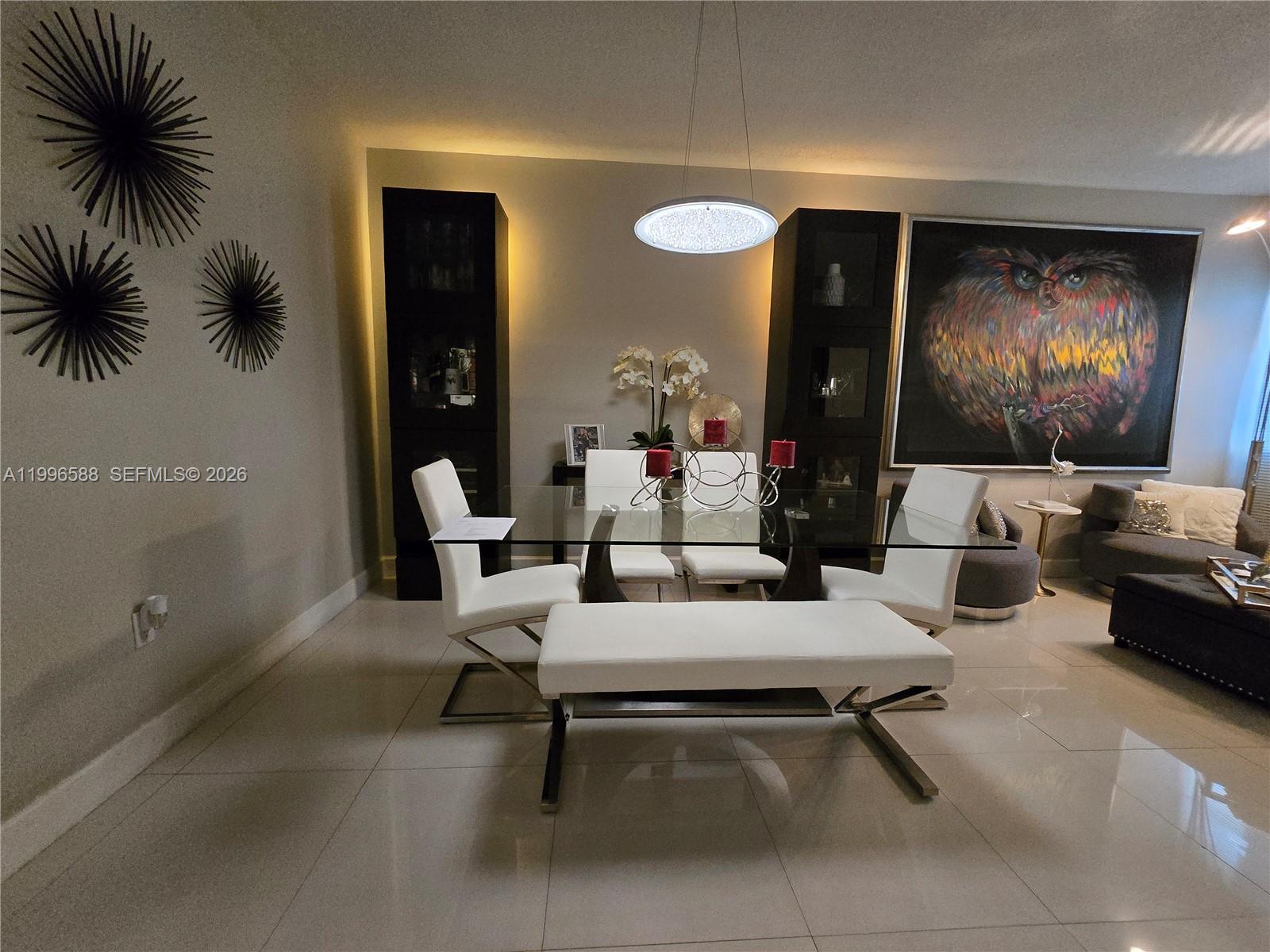 A dining room features a glass table, white chairs, a bench, and modern wall art — 8441 SW 124th Ave # 106, Miami FL 33183, MIAMI, FL