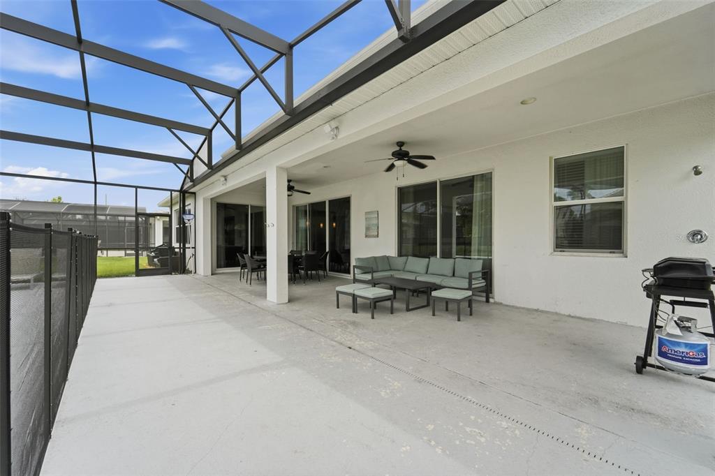 A covered patio features a concrete floor, outdoor furniture, a ceiling fan, and a screen enclosure — 3841 SONOMA BOULEVARD, KISSIMMEE, FL