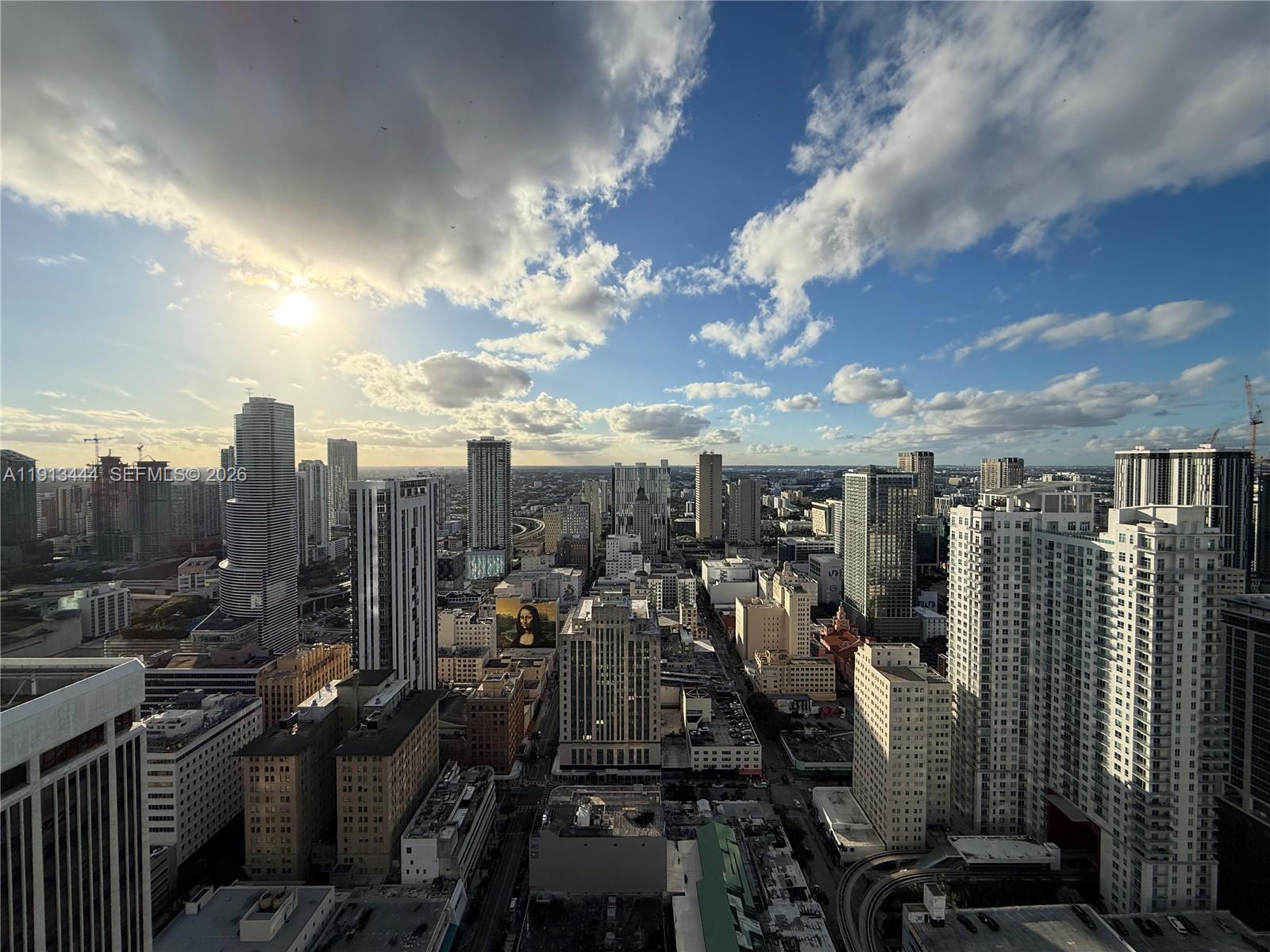 High-angle view of the Miami skyline featuring numerous skyscrapers under a cloudy blue sky — 50 Biscayne Blvd # 4807, Miami FL 33132, MIAMI, FL