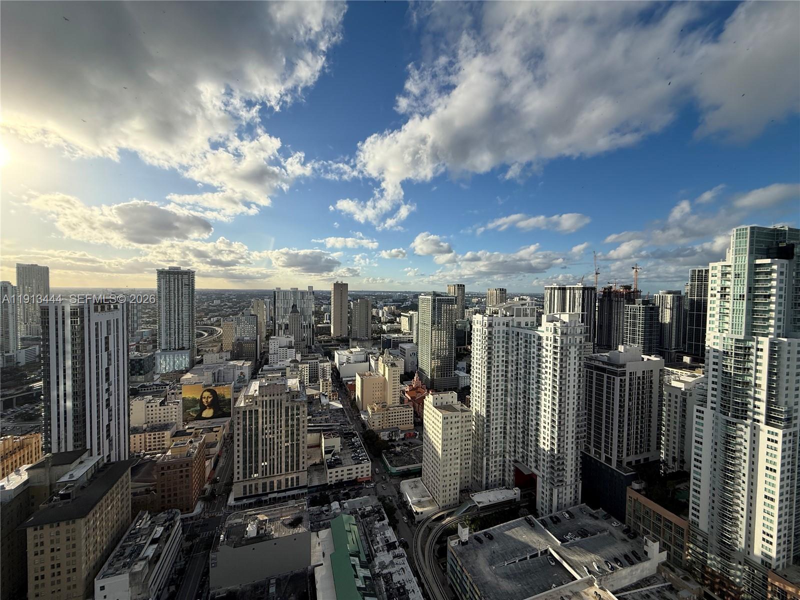 An elevated view of a dense city skyline featuring numerous high-rise buildings under a cloudy sky — 50 Biscayne Blvd # 4807, Miami FL 33132, MIAMI, FL