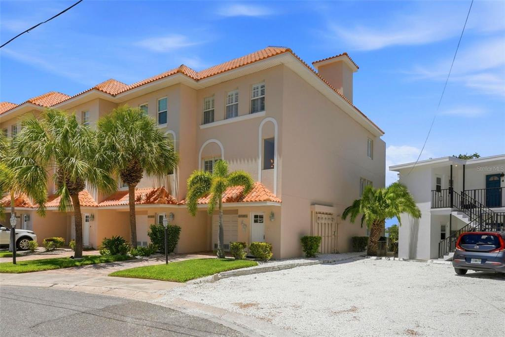 An aerial view shows a waterfront condominium complex with boat docks on a bay — 200 BRIGHTWATER DRIVE UNIT 10, CLEARWATER BEACH, FL