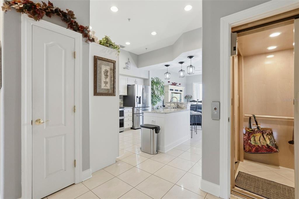 A residential elevator interior features light wood paneling, a control panel, and a hanging bag — 200 BRIGHTWATER DRIVE UNIT 10, CLEARWATER BEACH, FL