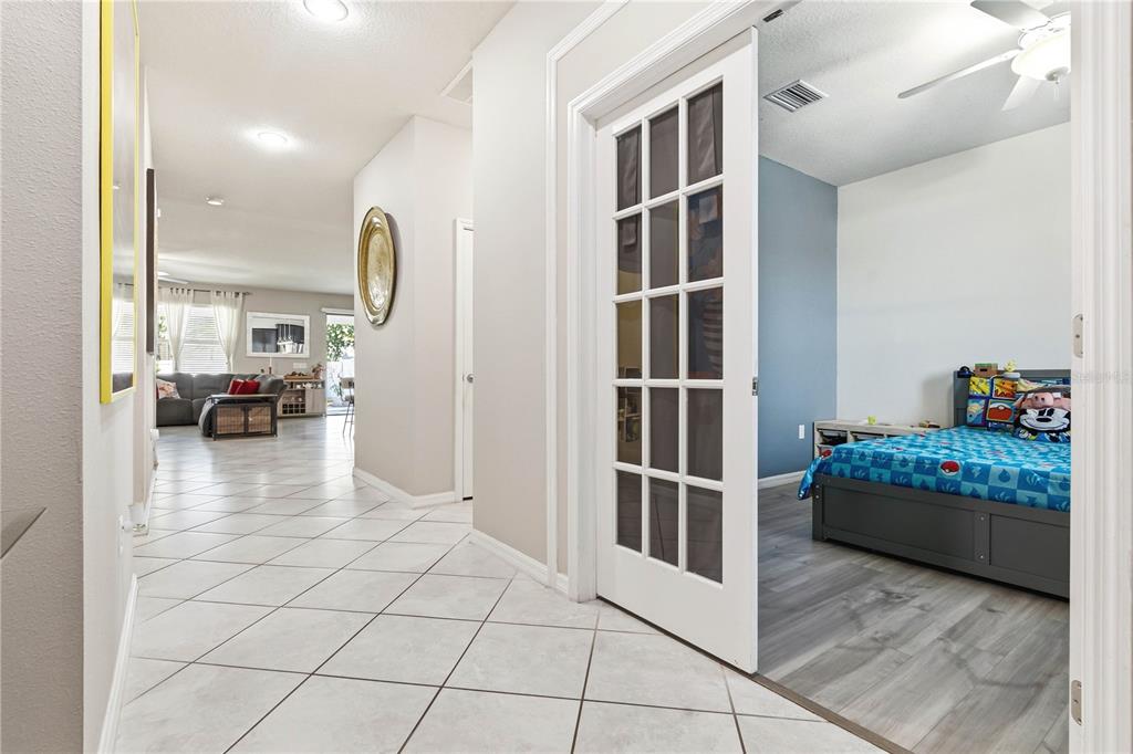 A tiled hallway leads to a living area and a bedroom with French doors — 11624 KILKENNY CORAL DRIVE, RIVERVIEW, FL