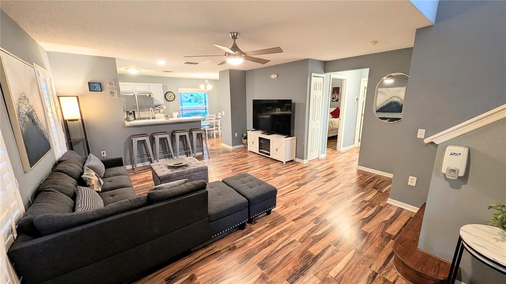 A screened-in pool area features lounge chairs, a tiled spillover spa, and golf course views — 2976 KOKOMO LOOP, HAINES CITY, FL