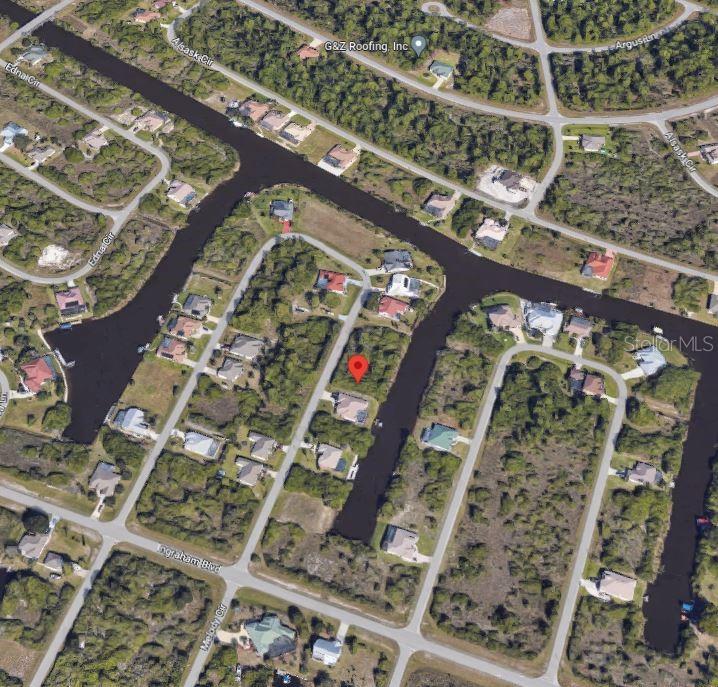 This aerial view shows a residential lot with a red pin located on a canal — 9270 MELODY CIRCLE, PORT CHARLOTTE, FL