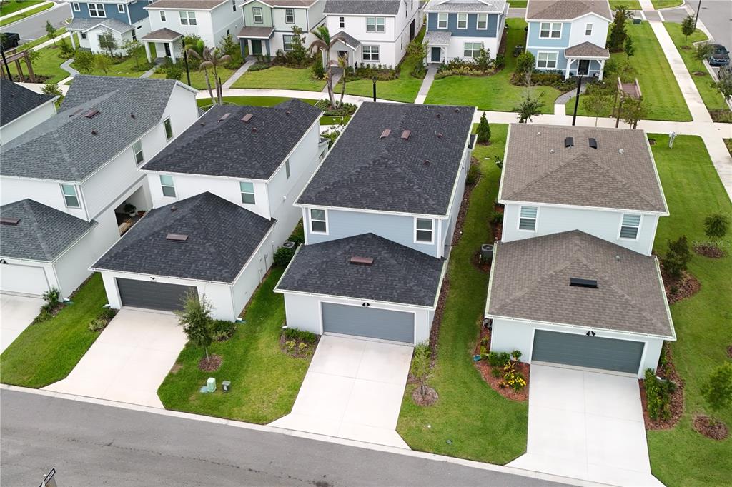 An aerial view shows three suburban houses with gray roofs and attached garages — 10922 FELICITY ALLEY, ORLANDO, FL