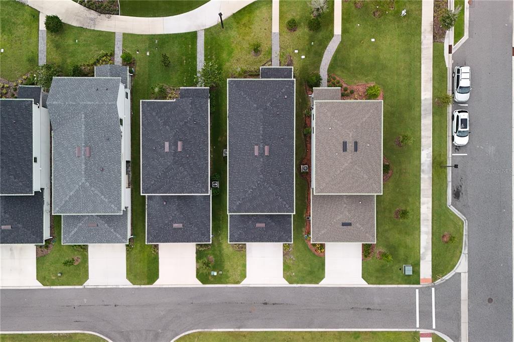 An aerial view shows four houses with driveways and lawns along a paved residential street — 10922 FELICITY ALLEY, ORLANDO, FL