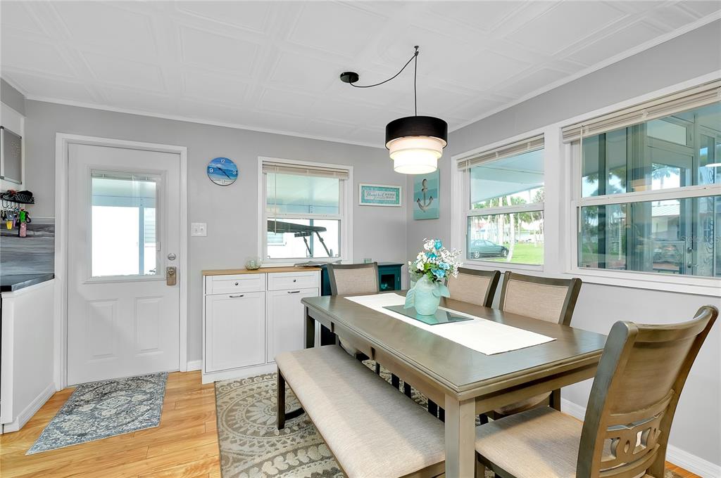 A dining room features a wooden table, a bench, chairs, and a light fixture — 214 ROMA ROAD, VENICE, FL