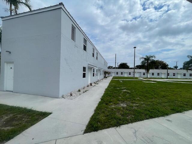 A two-story gray apartment building with a concrete walkway and a large grassy lawn — 4393 Windsor Avenue # 2, West Palm Beach FL 33407, WEST PALM BEACH, FL