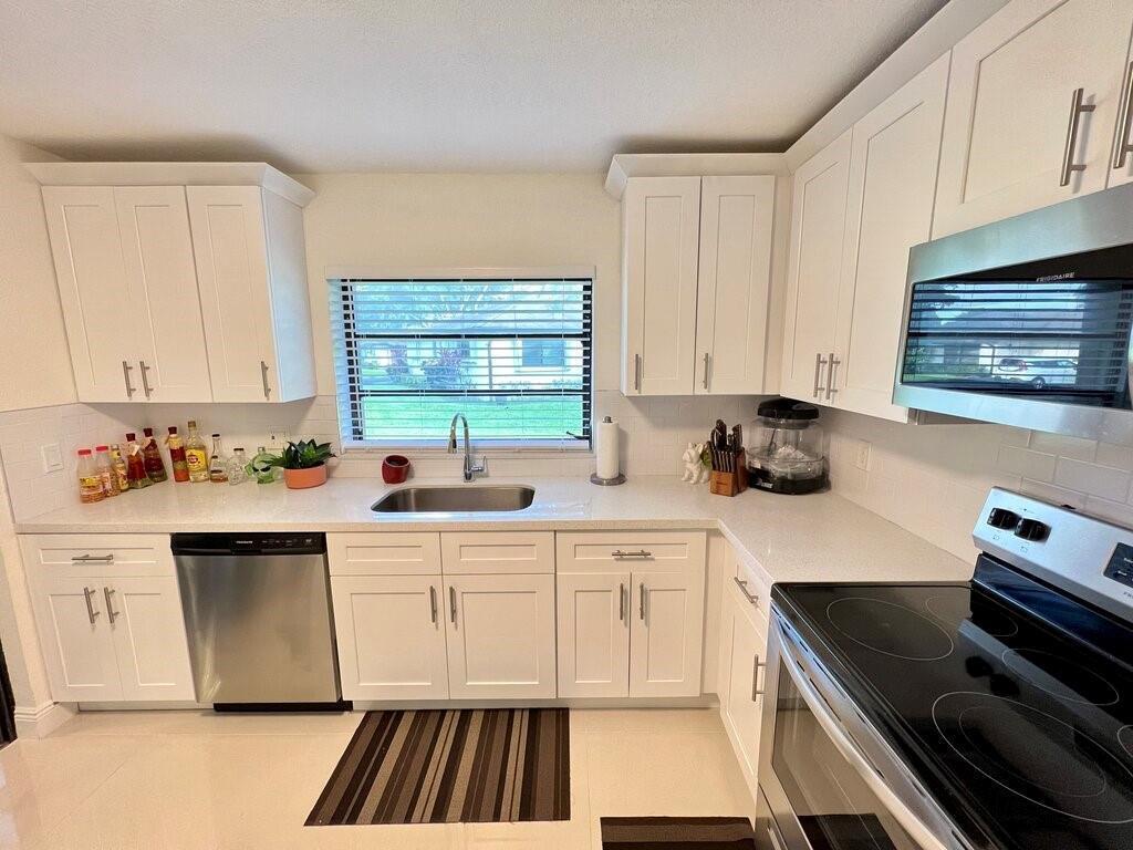 A kitchen with white cabinets, stainless steel appliances, a window above the sink, and countertops — 10151 Eaglewood Terrace # A, Boynton Beach FL 33436, BOYNTON BEACH, FL
