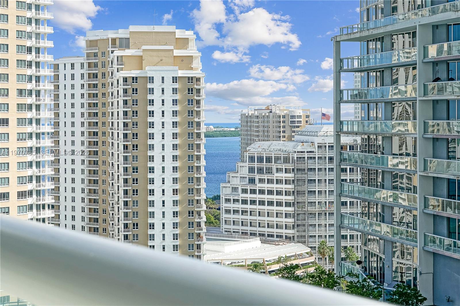 A view from a balcony overlooking several high-rise apartment buildings and a body of water — 475 Brickell Ave # 1913, Miami FL 33131, MIAMI, FL