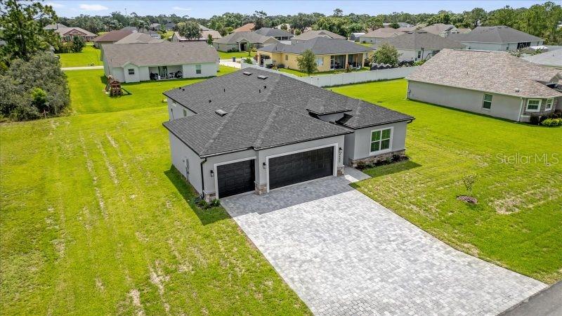 An aerial view shows a single-story house with a gray roof and paver driveway — 14733 SW 21 TERRACE, OCALA, FL