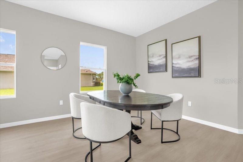A dining room features a dark oval table, four upholstered chairs, and two framed prints — 14733 SW 21 TERRACE, OCALA, FL