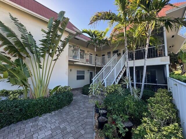 A two-story building with a white exterior, a staircase, and a paved walkway — 1361 NE 27 Way, Pompano Beach FL 33062, POMPANO BEACH, FL