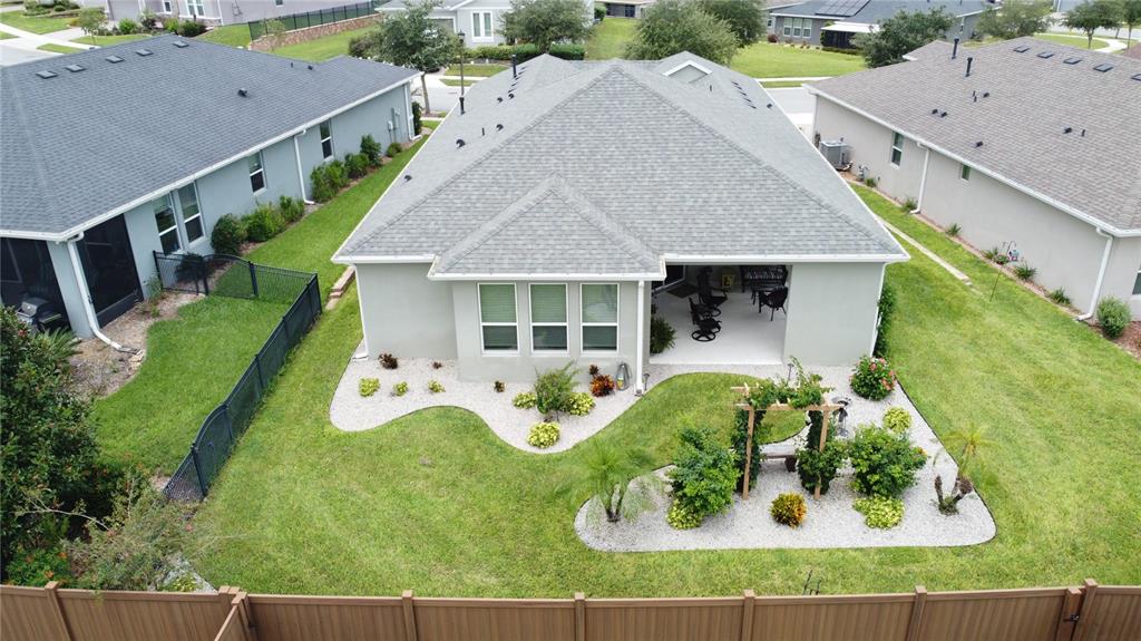 An aerial view of a house backyard featuring a covered patio, landscaping, and privacy fencing — 552 NARROW VIEW LANE, GROVELAND, FL