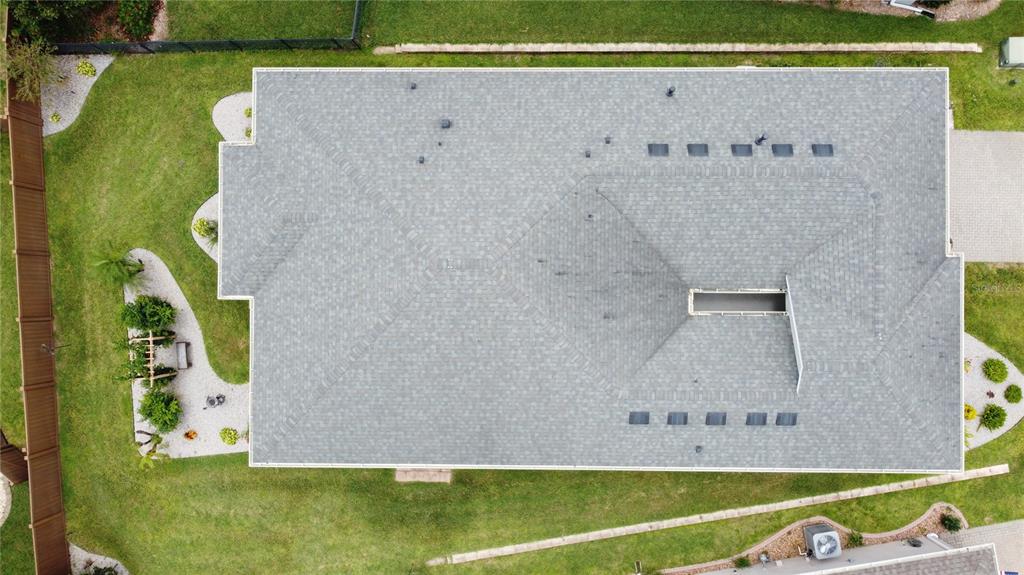 An aerial view shows the gray shingled roof of a house with a rectangular skylight — 552 NARROW VIEW LANE, GROVELAND, FL