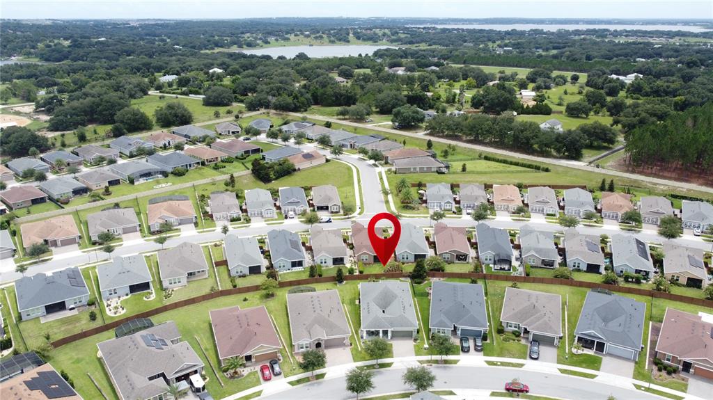 An aerial view shows a suburban neighborhood with a red pin marking a specific house — 552 NARROW VIEW LANE, GROVELAND, FL