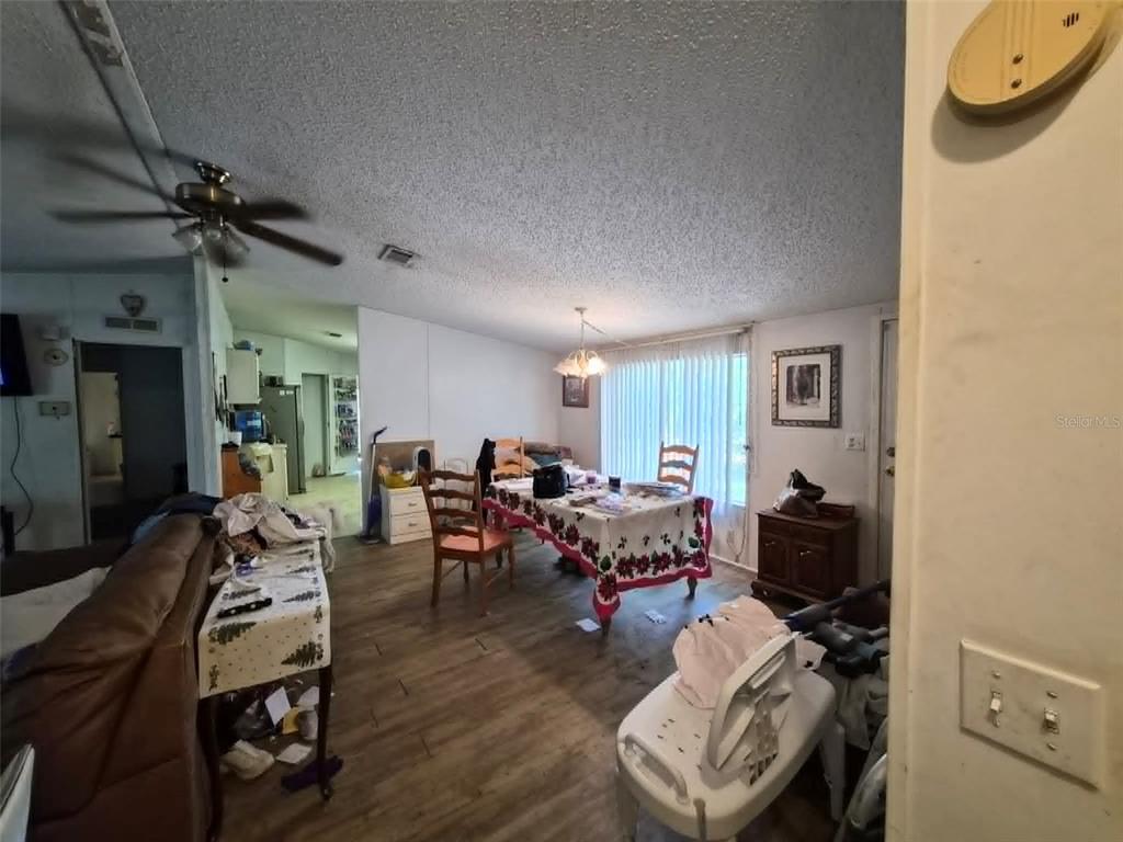 A living and dining area features wood-look flooring, a ceiling fan, and a dining table — 21508 NW 190TH AVENUE, HIGH SPRINGS, FL