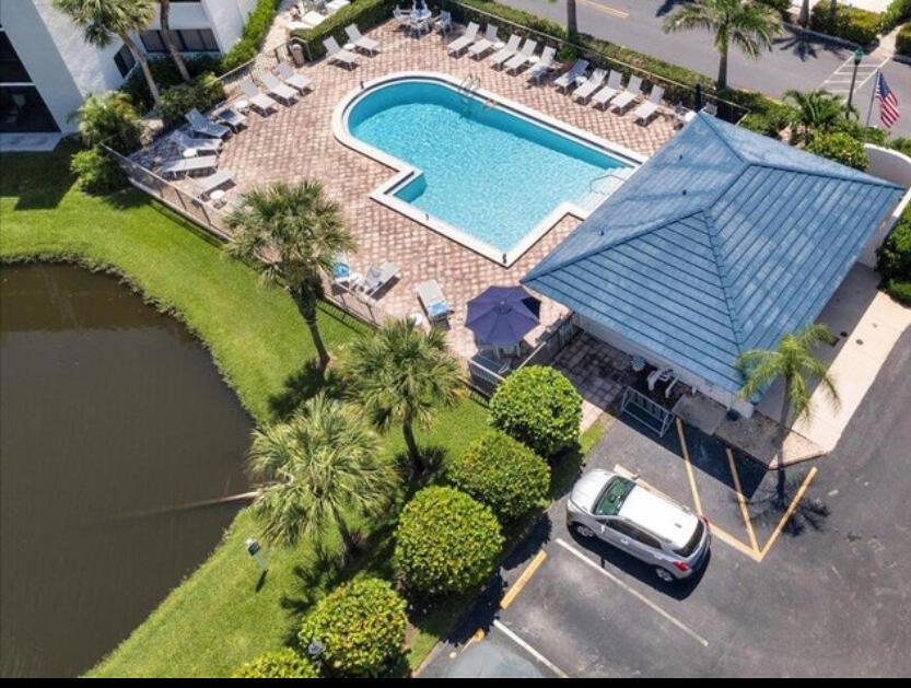 An aerial view shows a swimming pool, a covered patio, and a parking lot — 1605 S Us Highway 1 # E201, Jupiter FL 33477, JUPITER, FL