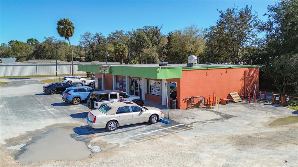 An aerial view of a single-story commercial building with a green roof and orange walls — 3030 W GULF TO LAKE HIGHWAY, LECANTO, FL