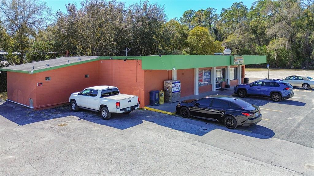 An exterior view of a single-story commercial building with an orange facade and green trim — 3030 W GULF TO LAKE HIGHWAY, LECANTO, FL