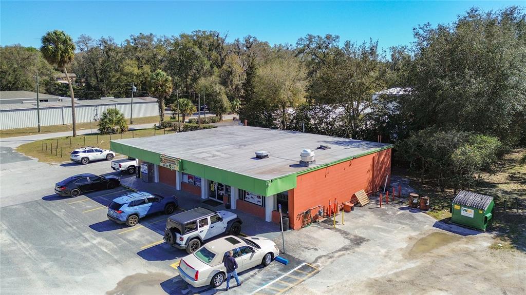 An aerial view shows a single-story commercial building with a parking lot and surrounding trees — 3030 W GULF TO LAKE HIGHWAY, LECANTO, FL