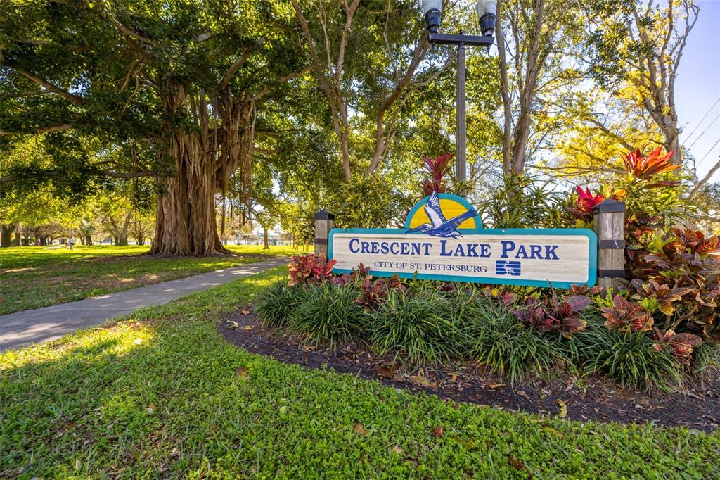 A sign for Crescent Lake Park stands in a grassy area with large trees — 711 12TH AVENUE N, ST PETERSBURG, FL