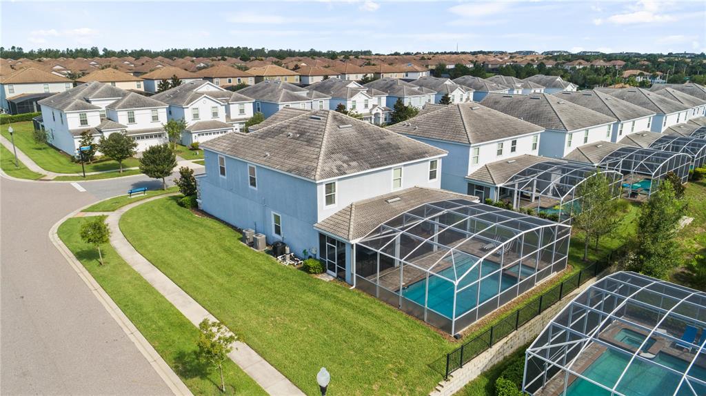 An aerial view shows a two-story house with a screened-in pool and backyard — 9098 HAZARD STREET, DAVENPORT, FL
