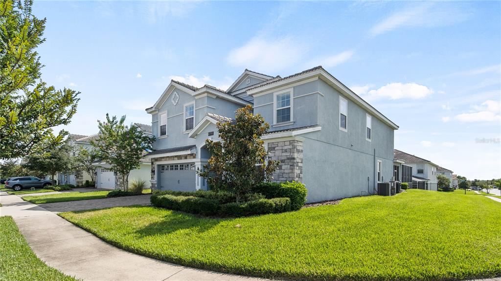 A two-story light blue house with a stone facade and a two-car garage — 9098 HAZARD STREET, DAVENPORT, FL