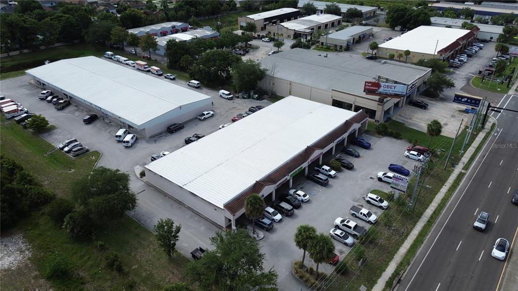 An exterior view of a commercial warehouse building with multiple roll-up doors and concrete walls — 11601 S ORANGE BLOSSOM TRAIL UNIT 204, ORLANDO, FL