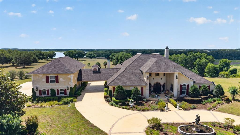 An aerial view of a large, two-story house with a driveway and a fountain — 17269 B SE 260TH AVENUE ROAD, UMATILLA, FL